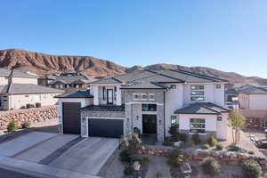 View of front of home featuring stone siding, stucco siding, driveway, and a mountain view