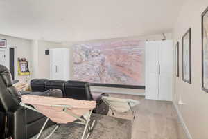 Living area featuring light carpet and baseboards