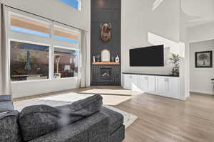 Living area with a towering ceiling and light wood-style flooring