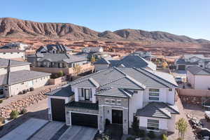 View of front of house with a residential view, stone siding, a mountain view, and concrete driveway