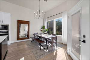 Dining room with light wood-type flooring and a chandelier