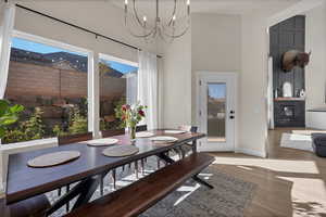 Dining space featuring wood finished floors, a high ceiling, and a chandelier