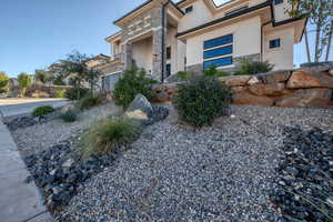 View of front facade featuring stone siding and stucco siding