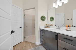 Full bath featuring vanity, a shower stall, and light wood finished floors