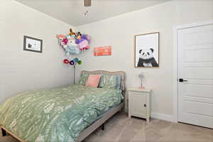 Carpeted bedroom featuring baseboards and ceiling fan