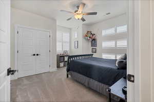 Bedroom featuring light carpet, ceiling fan, and a closet