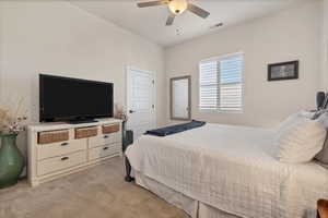 Bedroom with light carpet and a ceiling fan