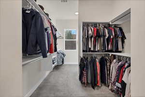 Walk in closet featuring light carpet