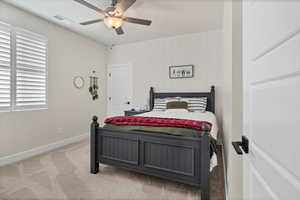 Carpeted bedroom featuring baseboards and a ceiling fan
