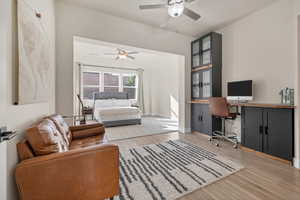 Home office featuring light wood-style floors and a ceiling fan