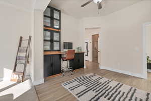 Office area with light wood-type flooring and ceiling fan