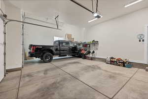 Garage featuring baseboards and a garage door opener