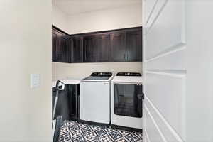 Washroom featuring separate washer and dryer and cabinet space