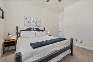 Carpeted bedroom featuring baseboards and ceiling fan