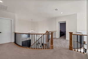 Corridor with recessed lighting, an upstairs landing, carpet floors, and a chandelier