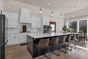 Kitchen with white cabinets, pendant lighting, black appliances, and recessed lighting