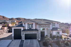 View of front of home with stone siding, driveway, stucco siding, and a mountain view