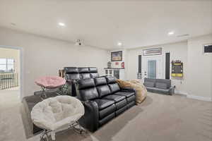 Carpeted cinema with recessed lighting and beverage cooler