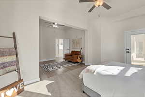 Carpeted bedroom featuring a ceiling fan and wood finished floors