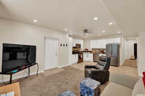 Living room featuring light carpet, recessed lighting, and a ceiling fan