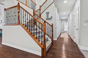 Stairs with hardwood / wood-style flooring and recessed lighting