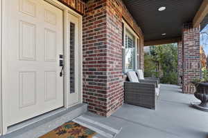 Doorway to property with brick siding and a porch