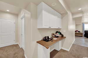 Hallway featuring recessed lighting and light carpet