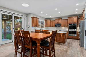 Dining area with light wood finished floors and recessed lighting