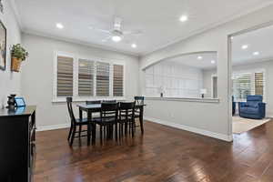 Dining area with ornamental molding, dark wood finished floors, recessed lighting, and ceiling fan