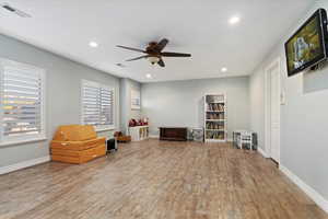 Living area featuring recessed lighting, light wood finished floors, and a ceiling fan