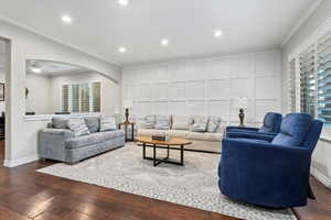 Living area featuring ornamental molding, recessed lighting, arched walkways, healthy amount of natural light, and a decorative wall