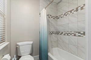 Bathroom with shower / tub combo and toilet