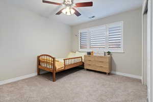 Bedroom featuring light carpet and a ceiling fan