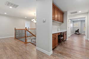 Hall featuring recessed lighting, an office area, an upstairs landing, light wood finished floors, and a chandelier
