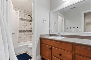Full bathroom featuring vanity, shower / bath combo, and light tile patterned flooring