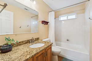 Full bath with shower / bath combination with curtain, vanity, and wood finished floors