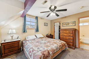 Carpeted bedroom with multiple windows, a ceiling fan, a spacious closet, and beam ceiling