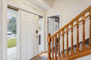 Foyer entrance with stairway and light wood-style floors