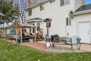 Back of property with a gazebo, a yard, a patio area, and a wooden deck