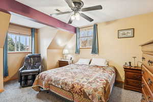 Carpeted bedroom featuring a ceiling fan