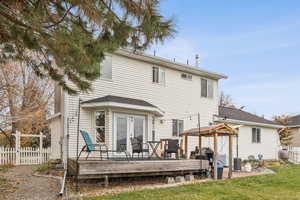 Back of property with a wooden deck and a shingled roof