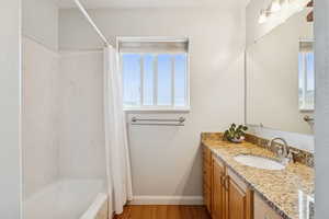Full bathroom featuring dark wood-style flooring, shower / tub combo, and vanity