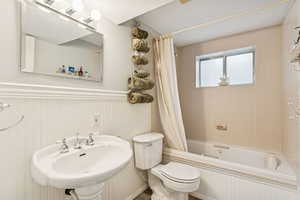 Bathroom with shower / bath combo and wainscoting