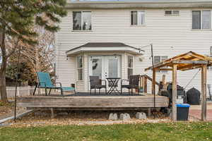 Rear view of house featuring a wooden deck and french doors