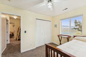 Bedroom featuring dark colored carpet, a mountain view, a closet, and ceiling fan