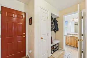 Mudroom featuring light tile patterned floors and baseboards