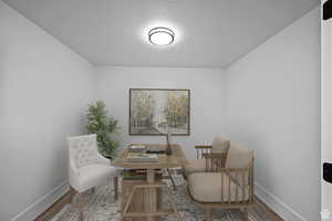 AI: Sitting room with wood finished floors, a textured ceiling, and a desk