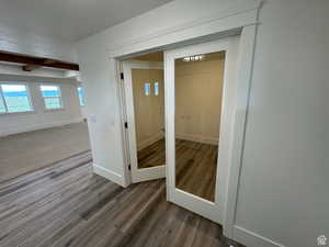 Detailed view of wood finished floors, beam ceiling, and french doors