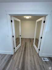 Corridor featuring french doors and light wood-type flooring