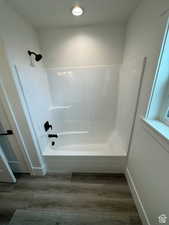 Full bathroom with shower / bathtub combination and wood finished floors